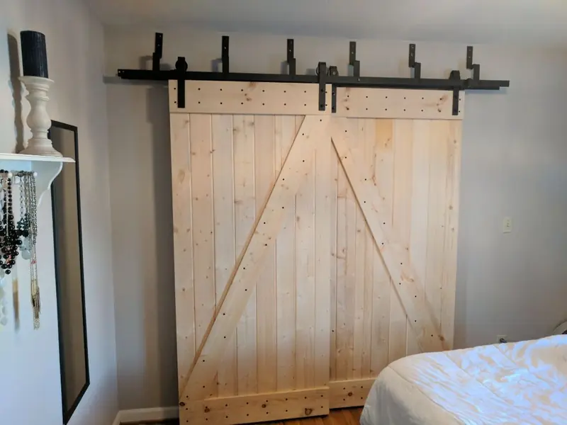 Pair of pine plank barn doors with Z-bracing on a black bypass track