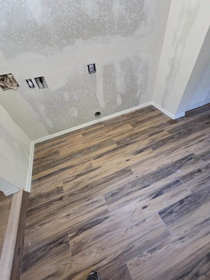 Wood-look plank flooring laid in a room with freshly patched drywall