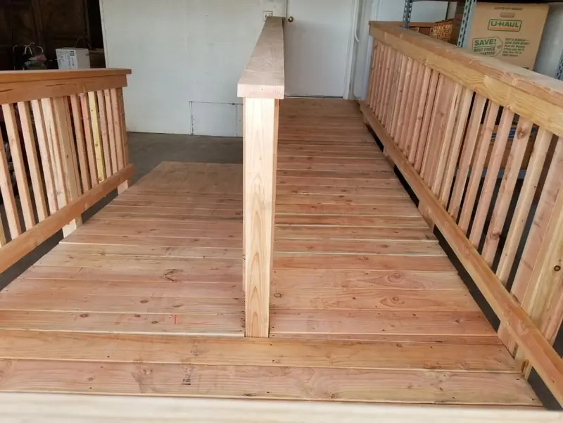 Looking down a wood access ramp with railings on both sides